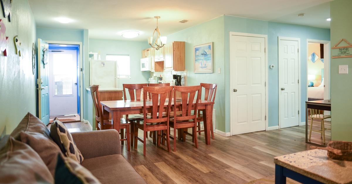 Gather around your spacious dining table where warm wood tones meet soft coastal blues, creating the perfect spot for meals and memories.