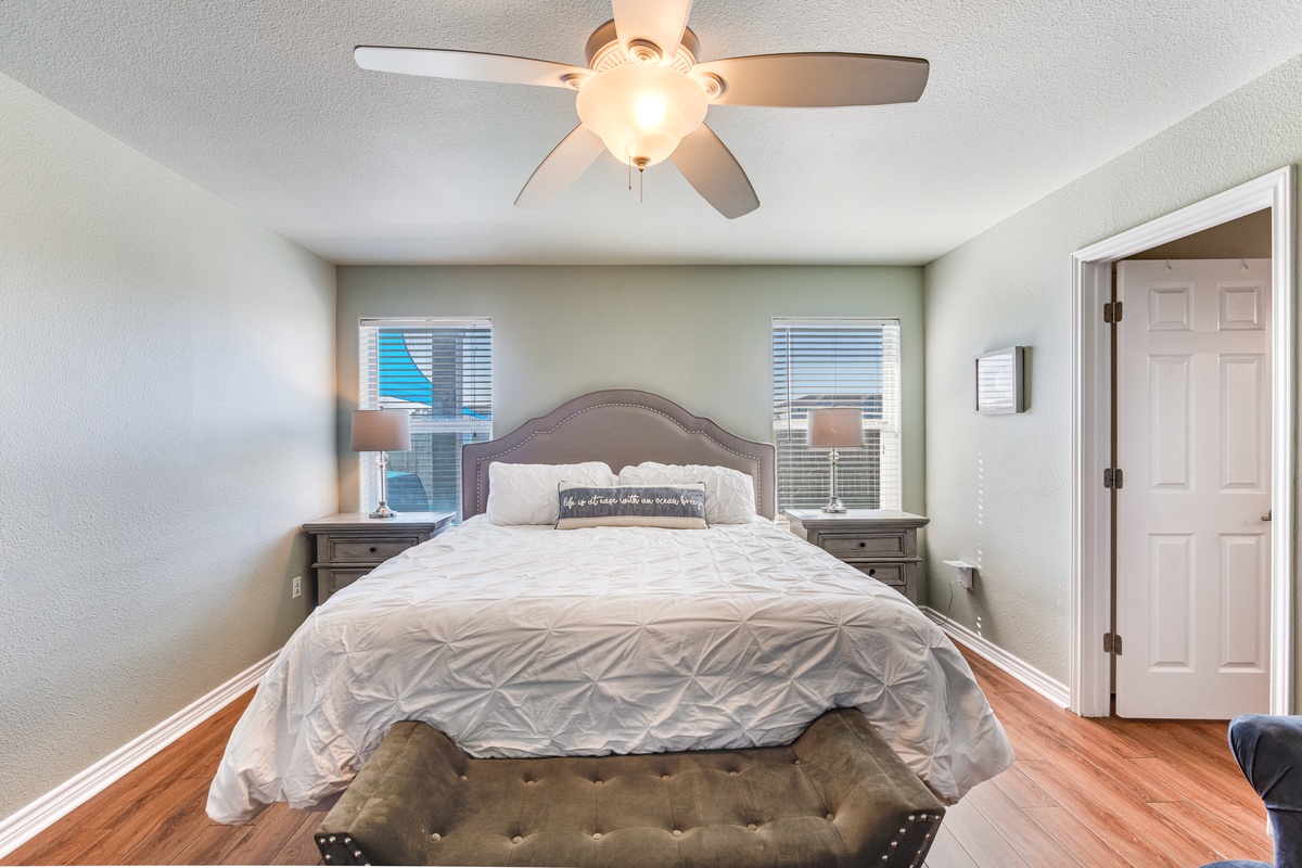 Drift off in your cozy bedroom with elegant tufted headboard, plush bedding, and gentle ceiling fan breeze.