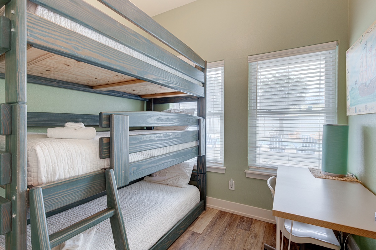 Your kids will love this cozy bunk room featuring fresh linens and a dedicated workspace for homework or games.
