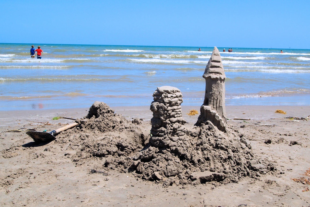 A beautiful sandy beach with sandcastles and gentle waves, perfect for family beach days and seaside relaxation.