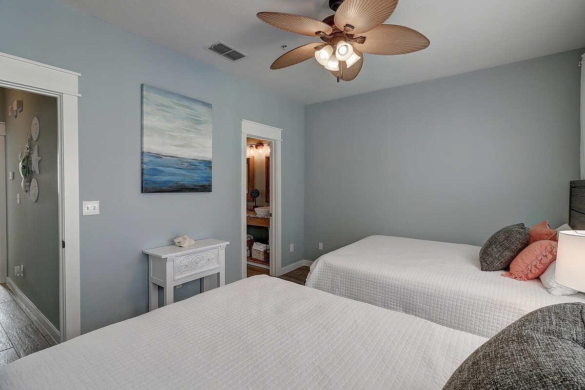 Drift off in this serene twin bedroom where coastal blues meet crisp whites. Your tropical ceiling fan keeps you cool while ocean artwork sets a peaceful mood.