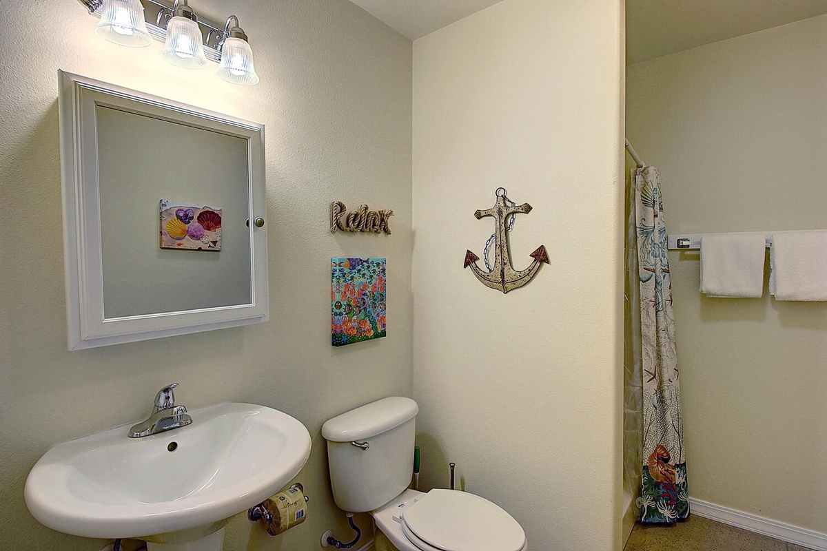 Your private bathroom features nautical charm with its anchor art and coastal touches, complete with fresh towels and thoughtful lighting.