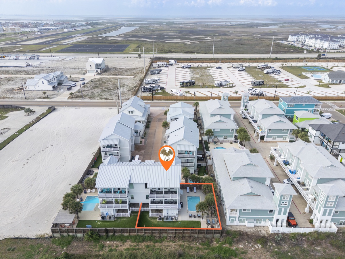 Aerial view of a modern beachfront community featuring contemporary vacation homes with private pools and easy beach access.