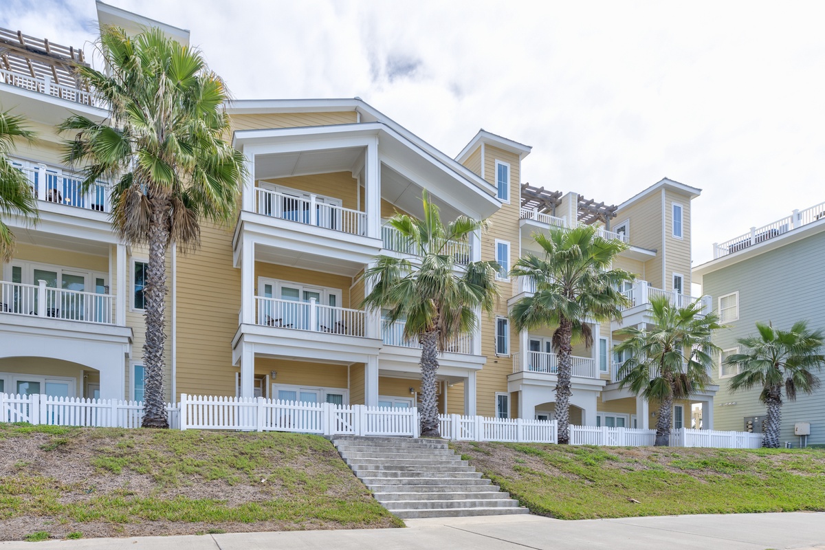 Modern beachside property featuring palm-lined architecture with spacious balconies and coastal charm.