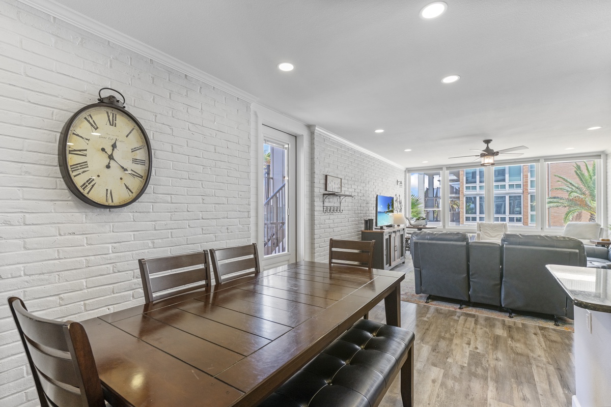 Unwind in your stylish dining and living space featuring exposed brick walls and large windows overlooking the vibrant cityscape.