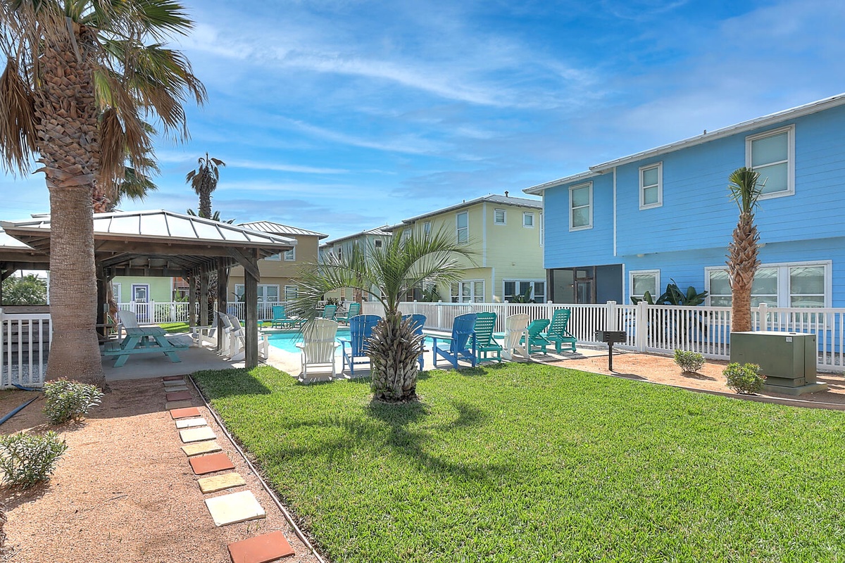 A tropical resort community featuring colorful beachside buildings, lush landscaping, and a sparkling pool area with convenient amenities.