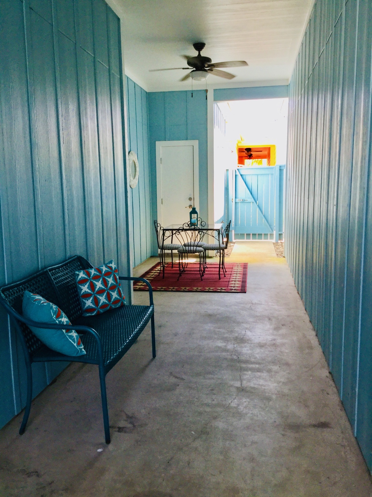 Step into your bright, breezy porch where turquoise walls and cozy seating create the perfect spot to unwind with morning coffee.