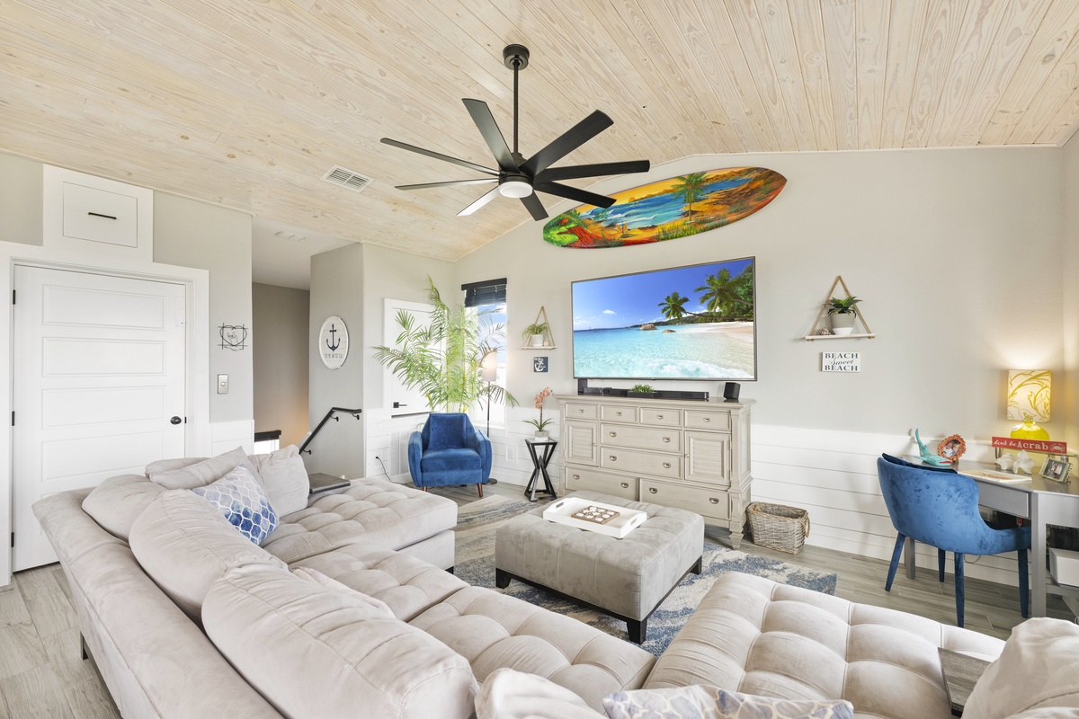 Unwind in your coastal-inspired living room where beach vibes meet modern comfort—plush seating and tropical touches create your perfect retreat.