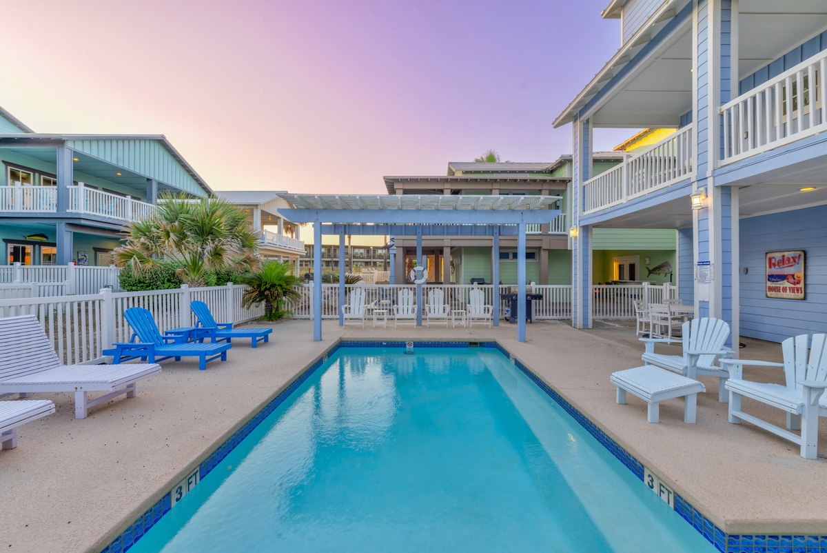 Coastal paradise awaits with your private pool surrounded by colorful beach chairs and tropical palms under stunning sunset skies.