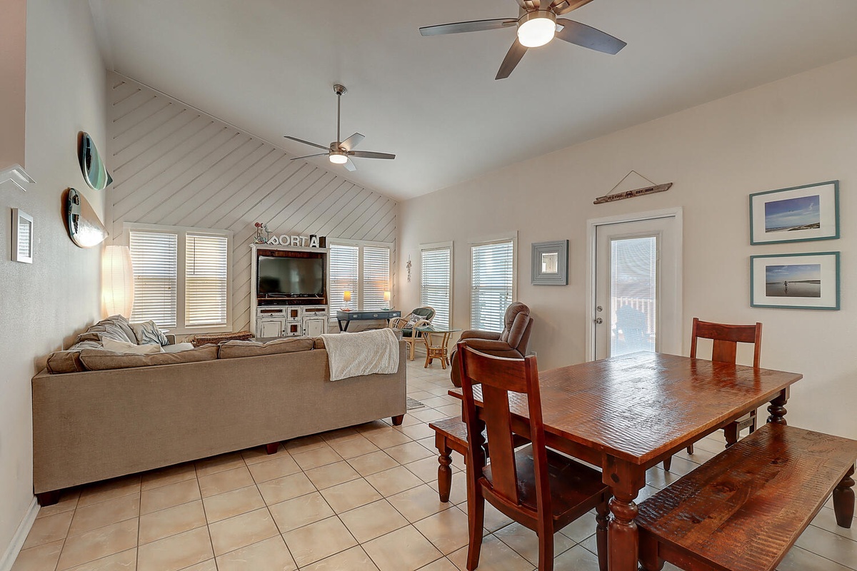 Relax in your spacious open-concept living space with comfortable seating, dining for family meals, and ceiling fans keeping you cool.