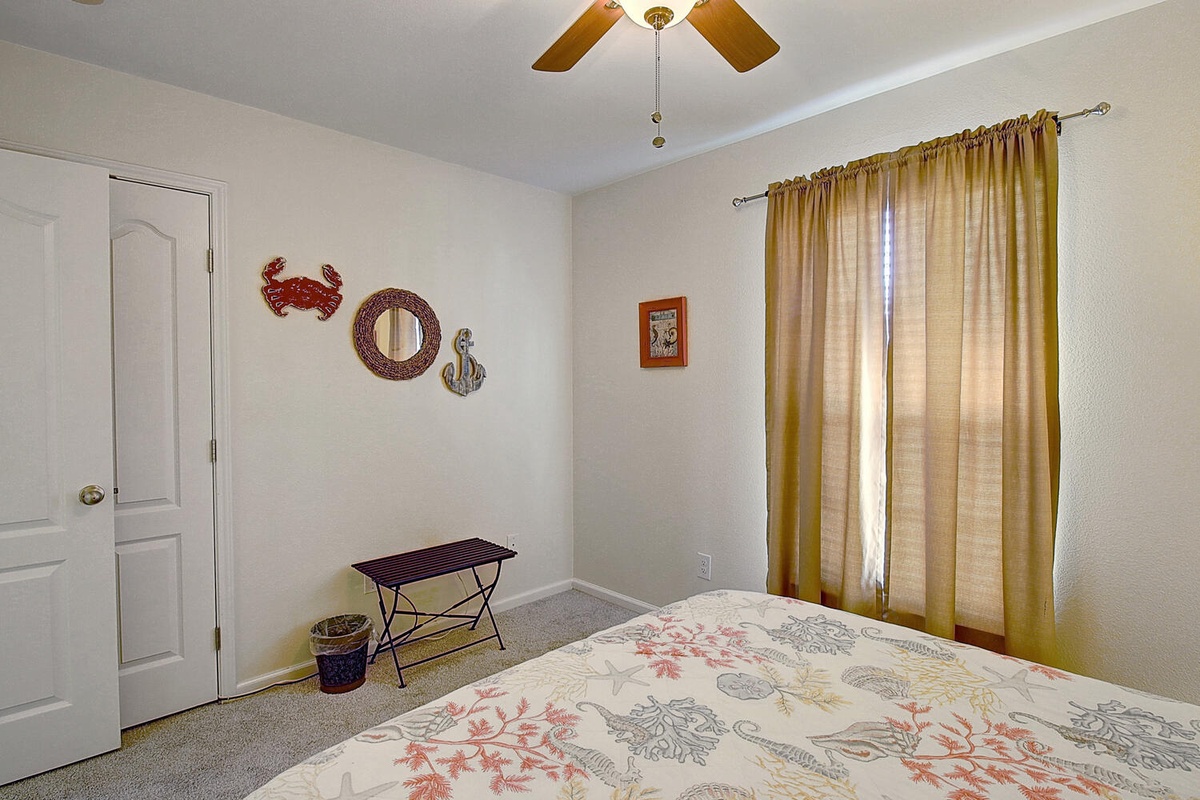 Your cozy bedroom features nautical charm with coastal decor, soft natural light, and comfortable furnishings for peaceful rest.