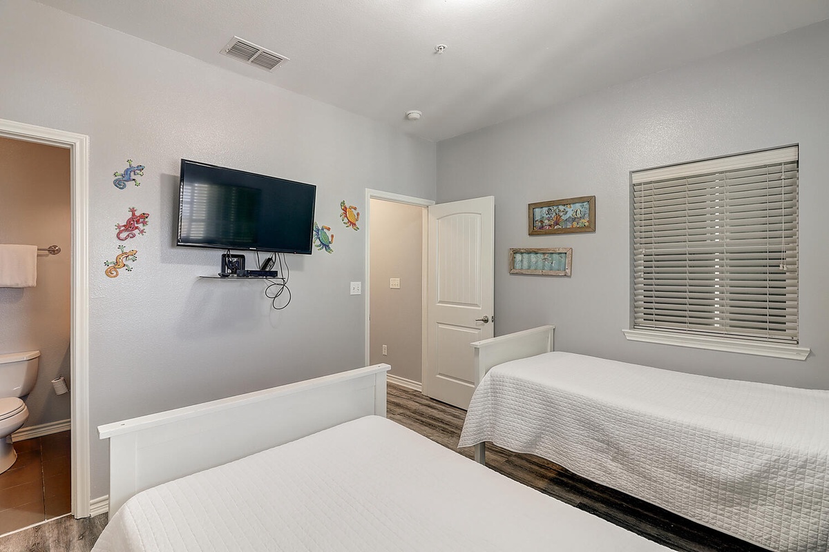 Your kids will love this cheerful bedroom with twin beds, fun wall decals, and their own TV for movie nights.