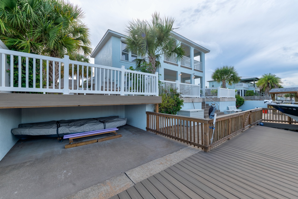 This coastal property features a multi-level deck surrounded by palm trees and waterfront access, offering a quintessential tropical retreat with dockside amenities.