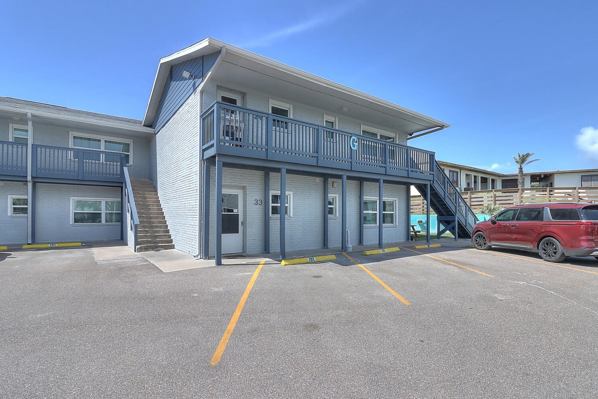 Modern two-story building with balcony access and convenient parking spaces located steps from the entrance.