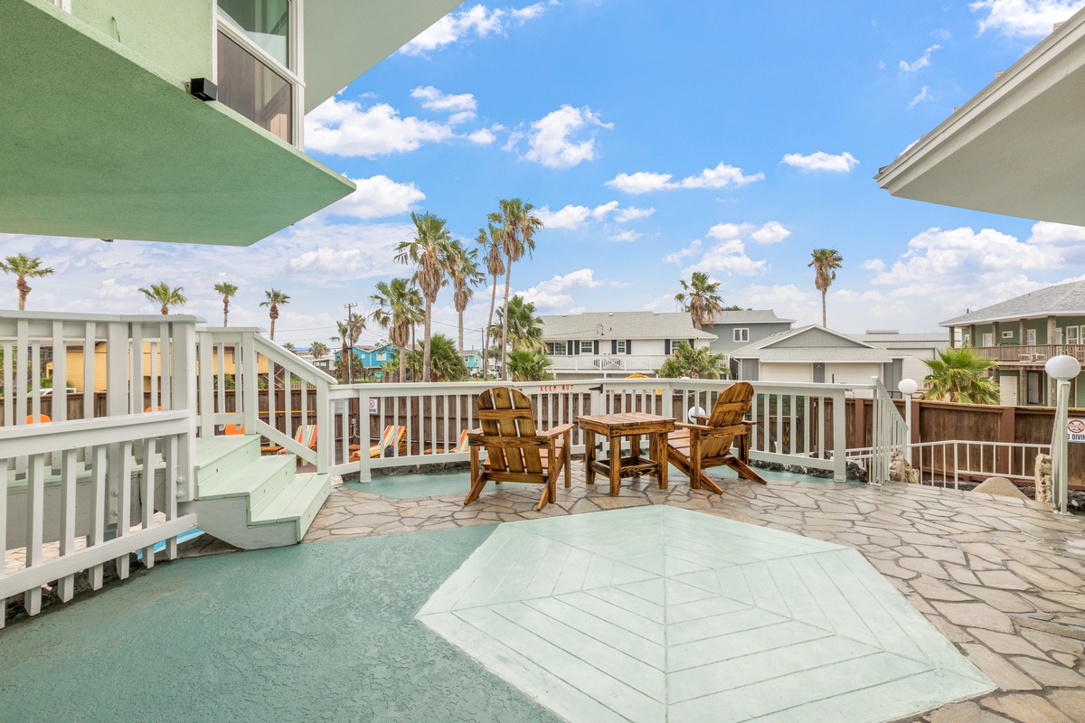 Step onto your private terrace with comfortable seating where you can unwind while soaking in palm-lined neighborhood views under sunny skies.