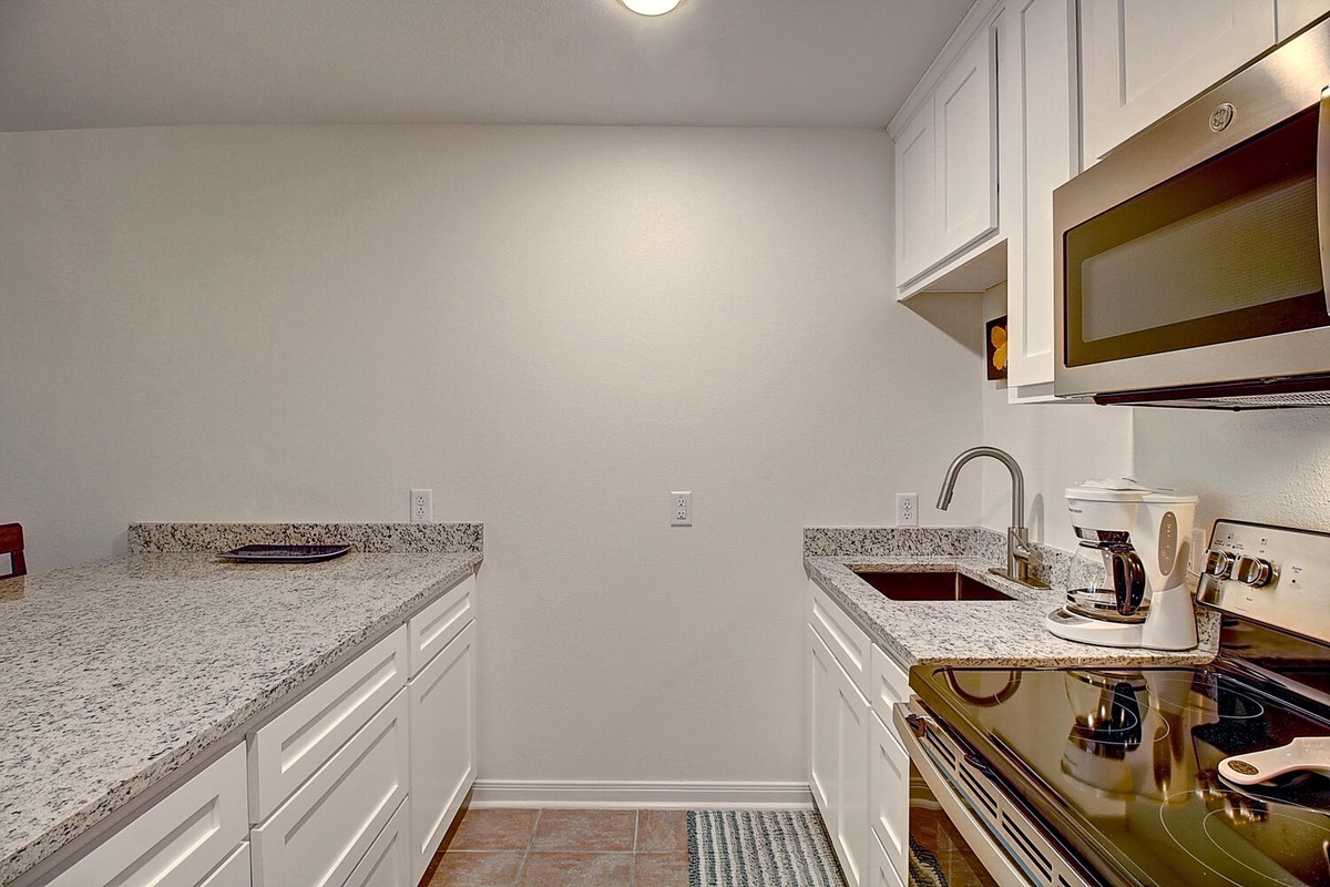 Cook your favorite meals in this well-equipped galley kitchen featuring granite countertops, stainless appliances, and everything you need for your stay.