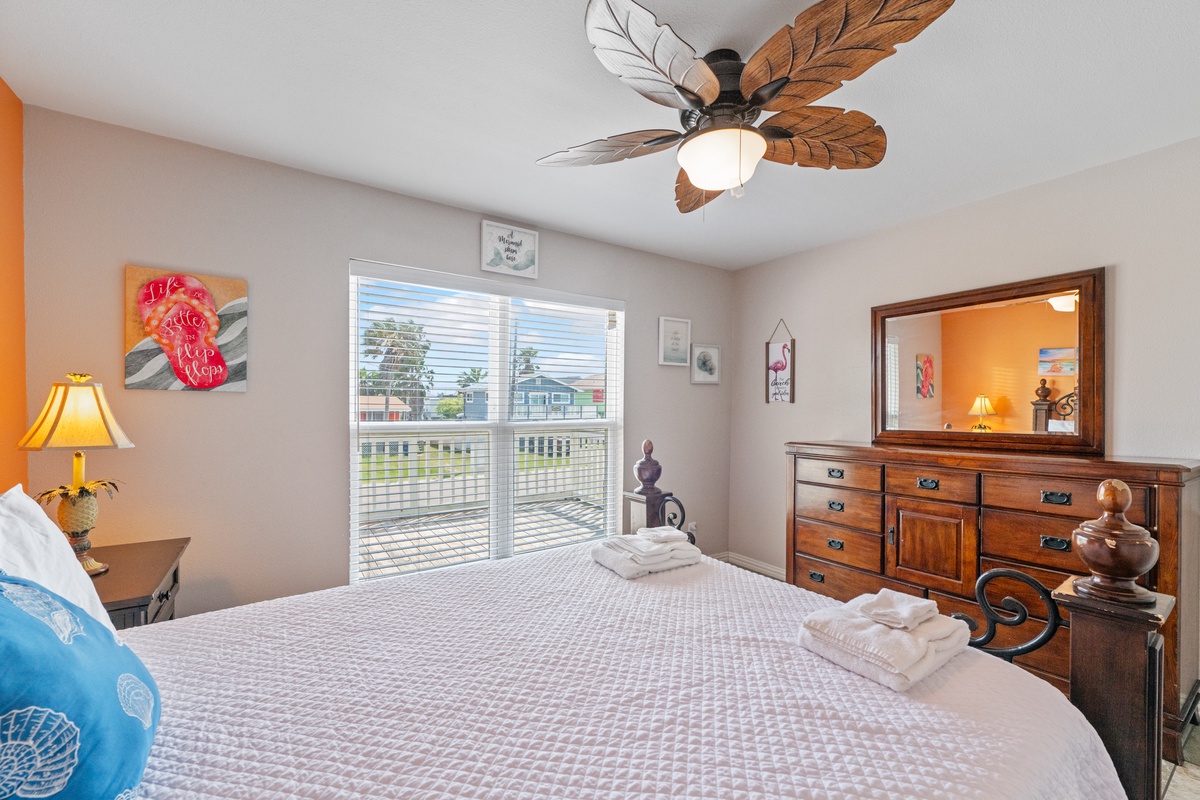 Drift off to sleep in your cozy bedroom, where tropical ceiling fans and warm furnishings create the perfect beach getaway ambiance.