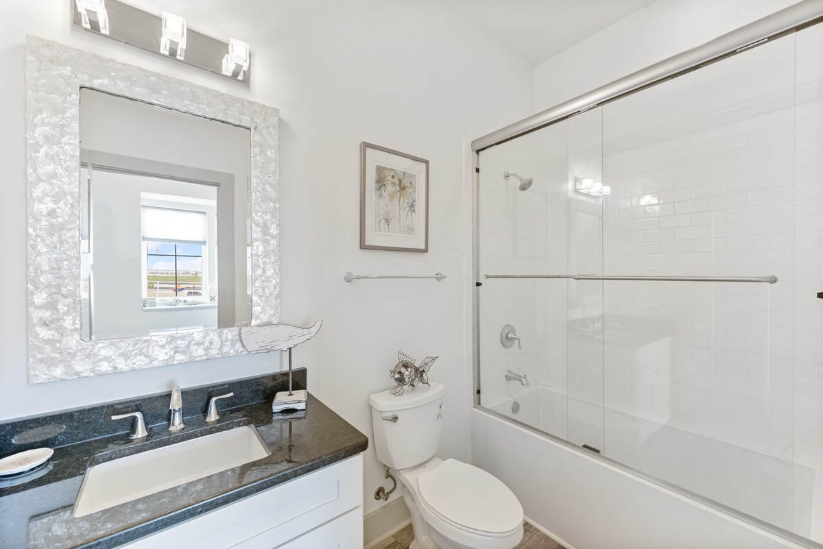 Unwind in your elegant bathroom featuring gleaming granite counters, a luxurious glass-enclosed tub, and thoughtful touches that make you feel pampered.