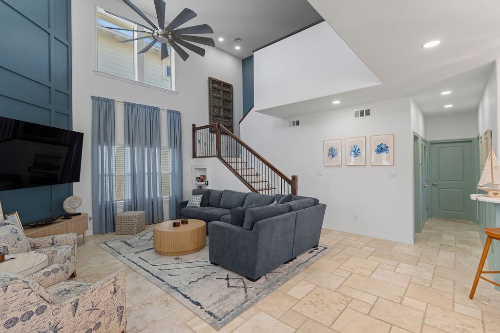 Unwind in your spacious living room with soaring ceilings, cozy sectional, and coastal touches that create the perfect gathering space.