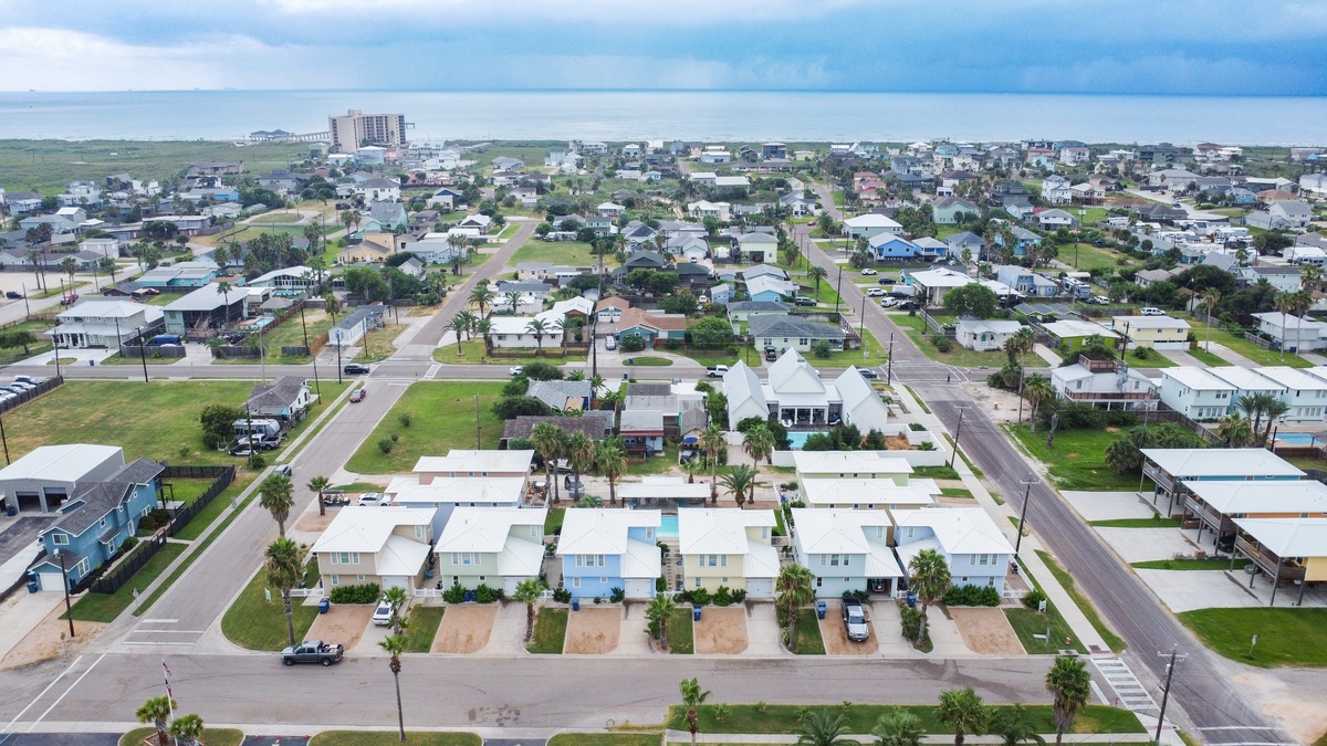 Aerial view of a coastal residential neighborhood with well-maintained streets and nearby beach access.