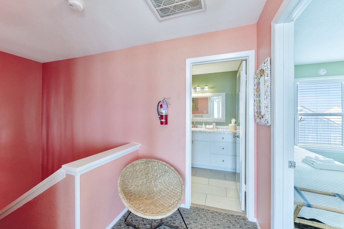 Settle into your sunny coral sanctuary with charming wicker seating and easy access to your private ensuite bathroom.
