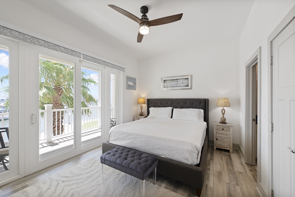 Wake up to tropical palm views from your private balcony in this serene bedroom with crisp linens and gentle ceiling fan breezes.