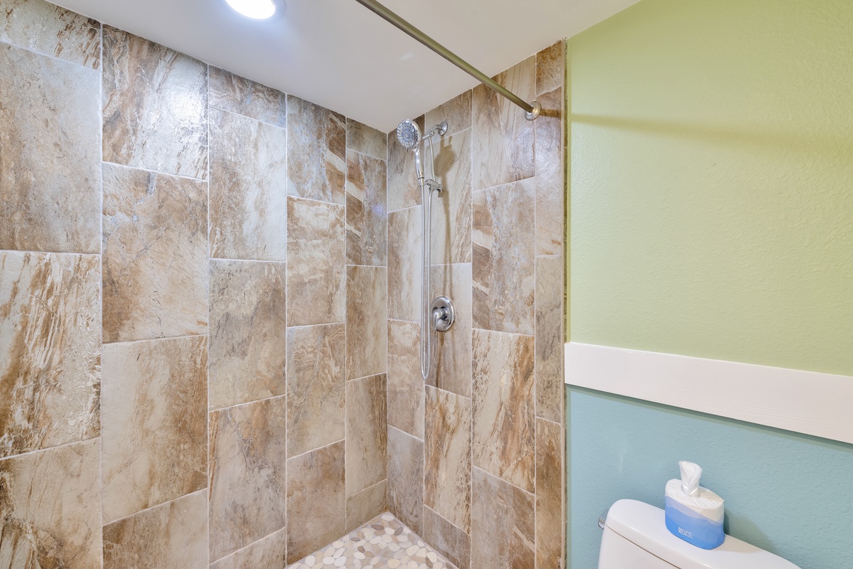 Refresh in your beautifully tiled walk-in shower with modern fixtures and natural stone patterns.