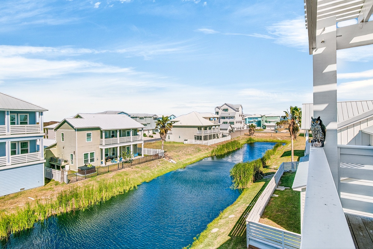 Scenic waterfront community with canal views, coastal homes, and palm trees creating a peaceful residential setting.