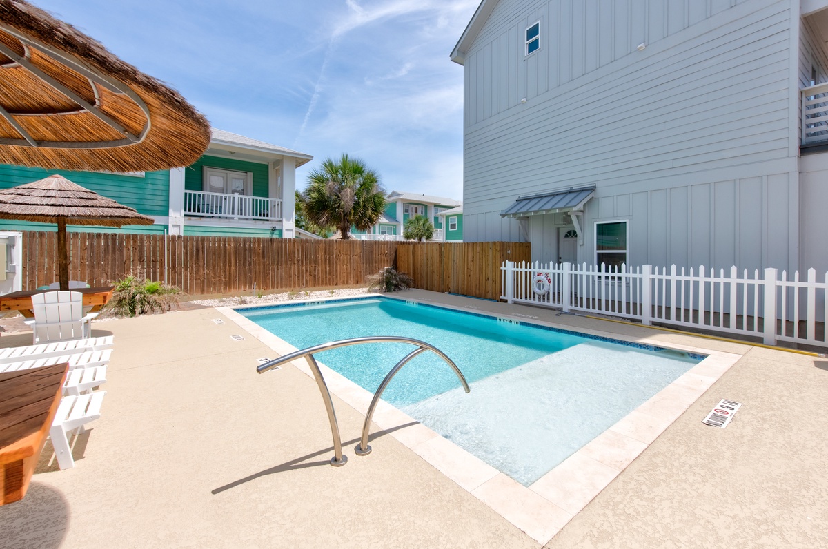 Dive into the sparkling community pool waters and tropical shade umbrellas creating the perfect backyard retreat.