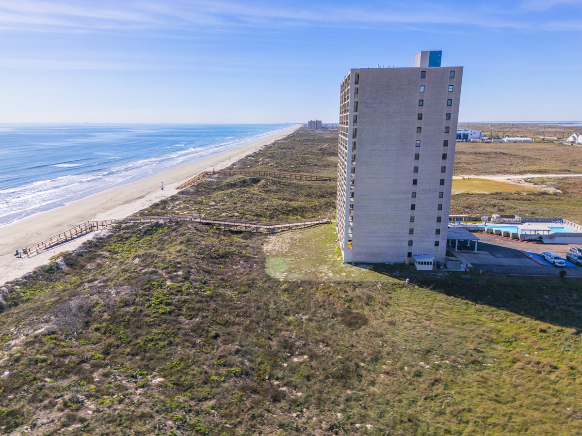 Aerial view of beachfront property offering direct access to pristine coastline and natural dunes.
