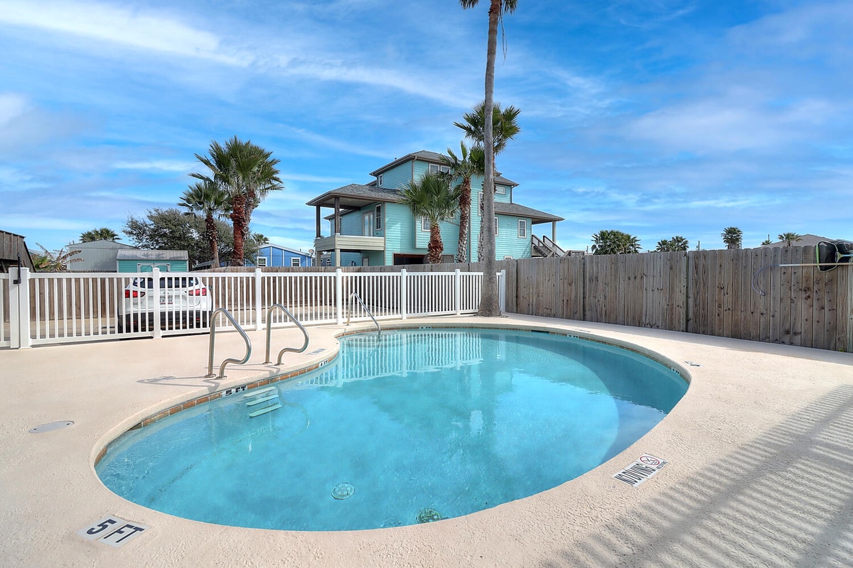 Dive into crystal-clear waters surrounded by swaying palms and beach house charm in your private poolside paradise.