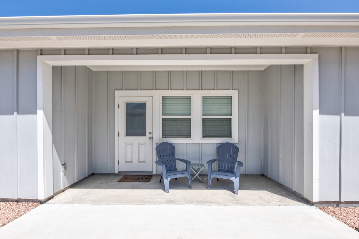 Charming covered entrance with blue Adirondack chairs where you can relax and soak in the peaceful surroundings.