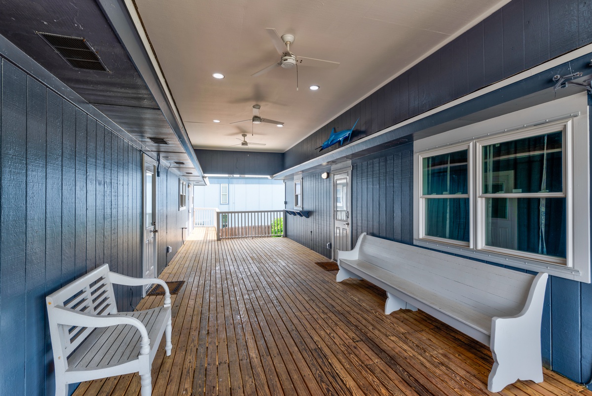 Your covered porch offers charming white benches and warm wood floors - perfect for morning coffee or evening relaxation.