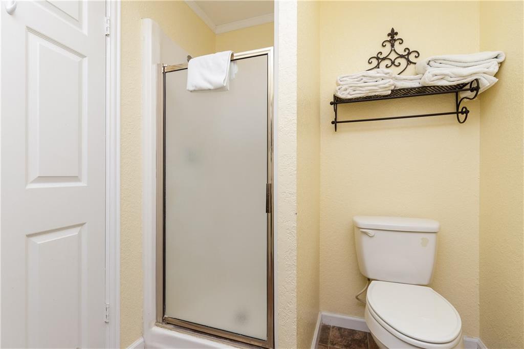 Your private bathroom features a spacious shower and thoughtful touches like fresh towels on decorative shelving for your comfort.