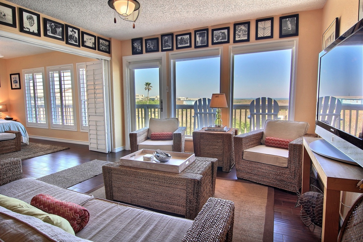 Sink into plush wicker seating while you gaze at endless ocean views through floor-to-ceiling windows in this bright, airy living space.