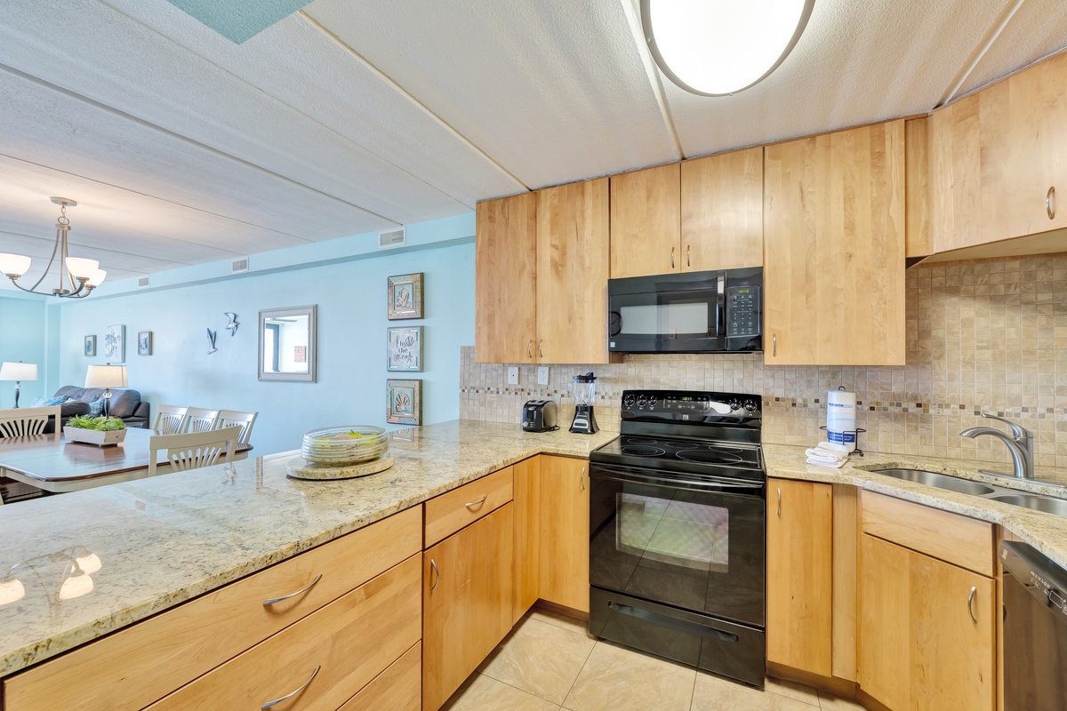 Cook your favorite meals in this bright, modern kitchen with granite countertops and natural wood cabinets overlooking the living area.