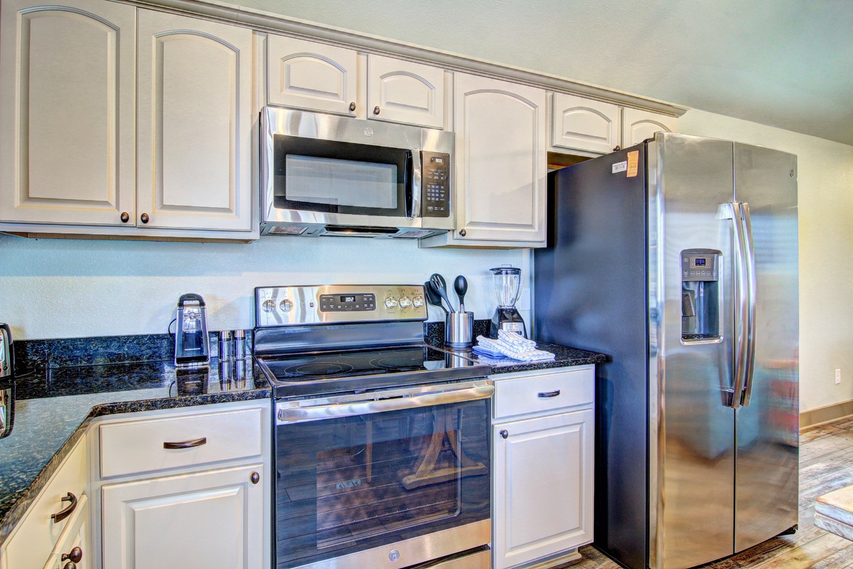 Cook your favorite meals in this sleek kitchen featuring modern stainless appliances, granite counters, and ample cabinet space for all your culinary adventures.