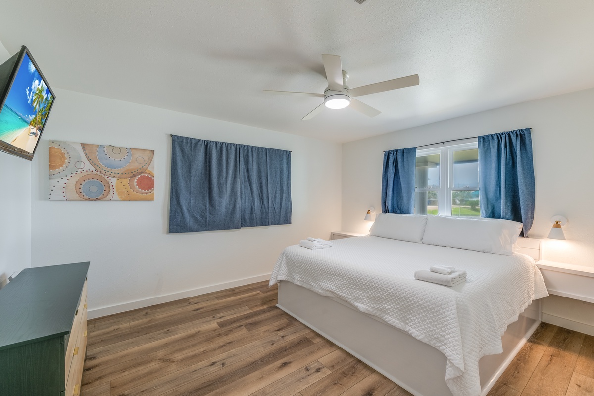 Unwind in your bright, peaceful bedroom with comfortable linens, modern ceiling fan, and entertainment ready for relaxing evenings.
