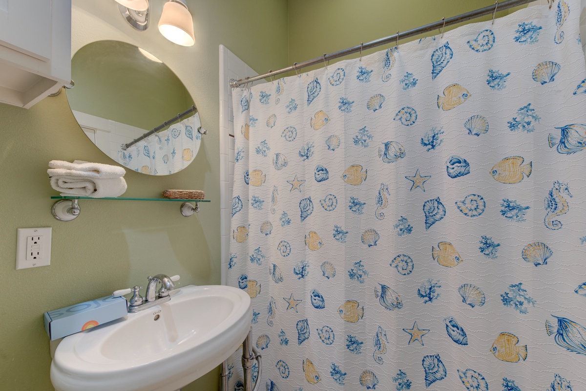 Your bathroom features soothing coastal-themed decor with fresh towels and modern fixtures to make your stay comfortable.