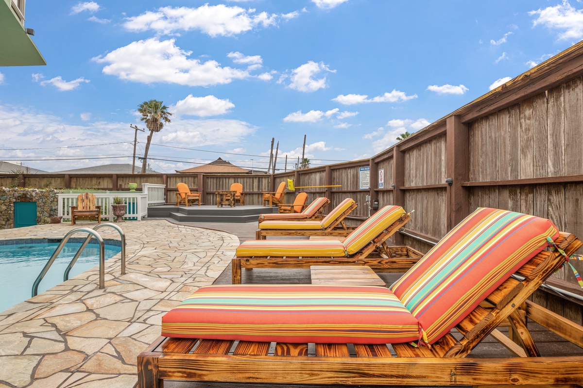 Soak up the California sun on vibrant striped loungers by your private pool, where palm trees sway overhead.