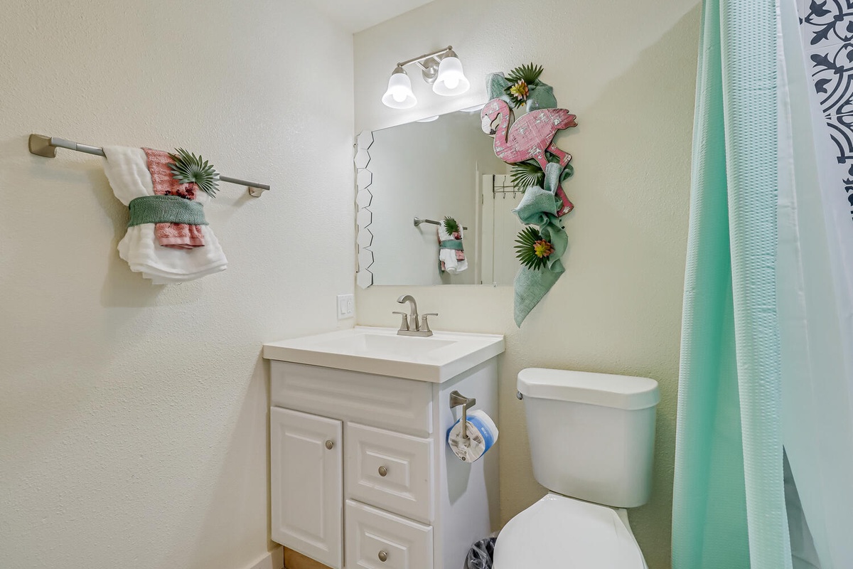 Your charming bathroom features tropical touches and fresh towels, creating a cheerful space for your morning routine.