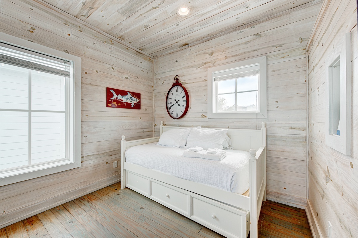 Drift off to sleep in your cozy wood-paneled bedroom, where rustic charm meets modern comfort with built-in storage beneath crisp white linens.