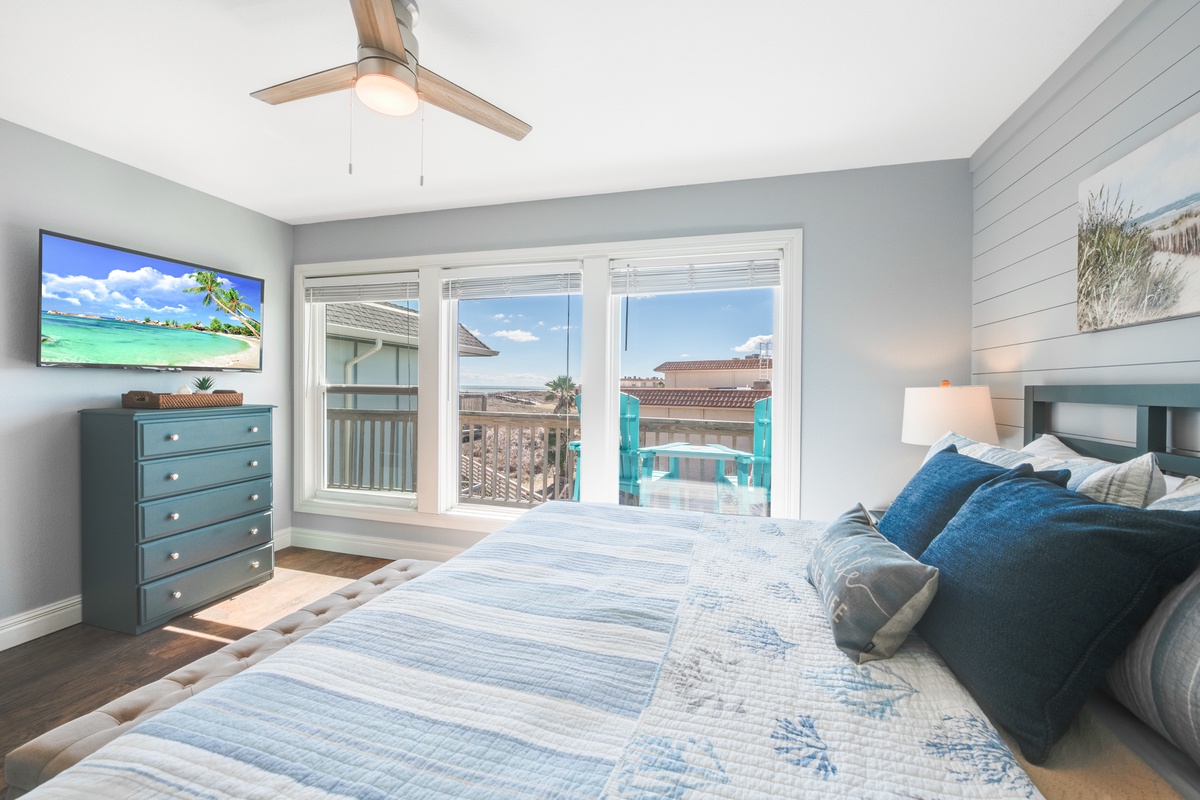 Wake up in your serene coastal bedroom with ocean breezes from the ceiling fan and stunning views through expansive windows.