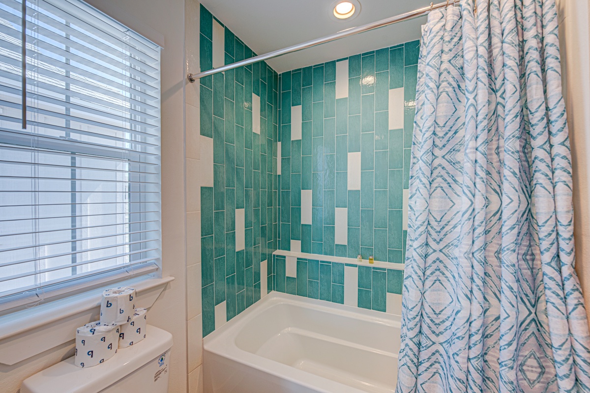 Refresh in this bright bathroom featuring stunning turquoise tile work and modern amenities for your comfort.