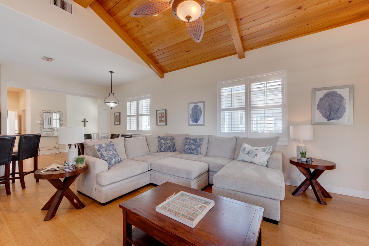Relax in your bright, airy living room with vaulted wood ceilings and plush sectional seating, perfect for unwinding after coastal adventures.