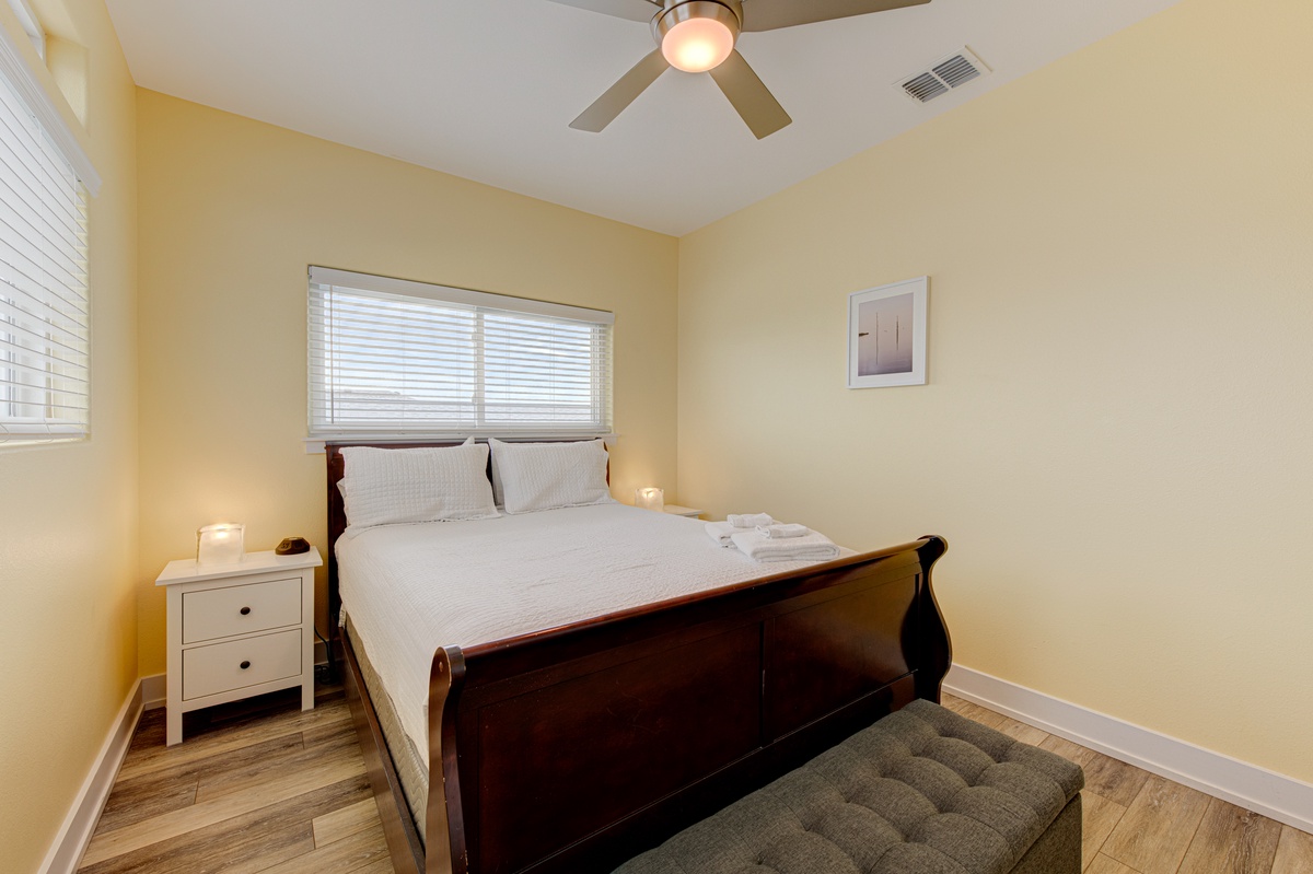 Sink into crisp linens and let the ceiling fan's gentle breeze lull you to sleep in this cozy bedroom.