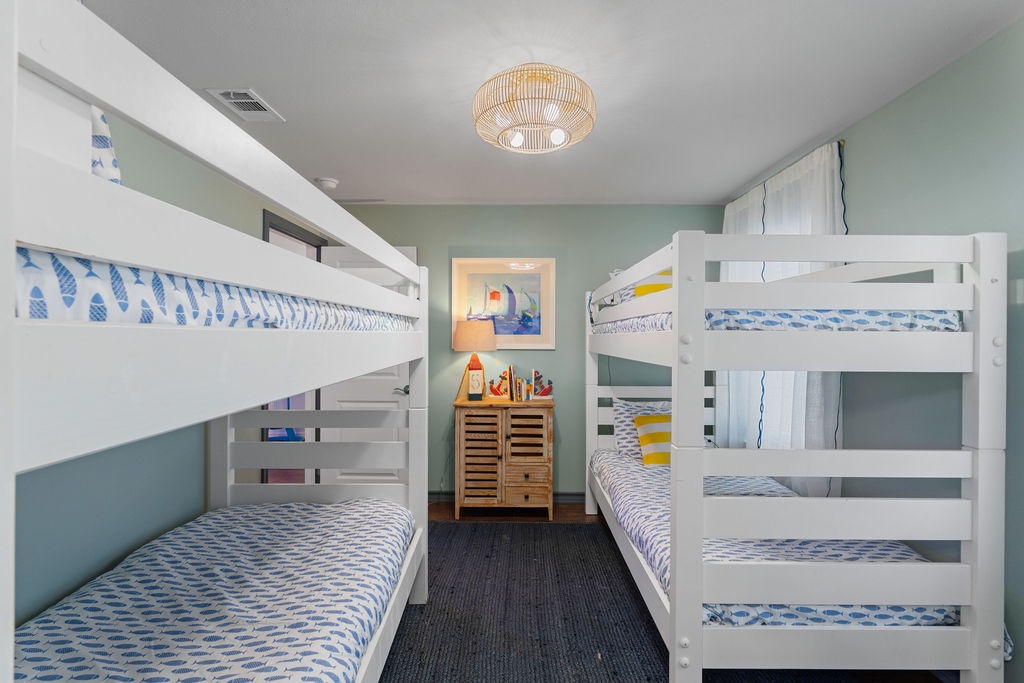 Your family's cozy bunk room features sturdy white beds with cheerful blue bedding, perfect for kids' adventures and restful nights together.