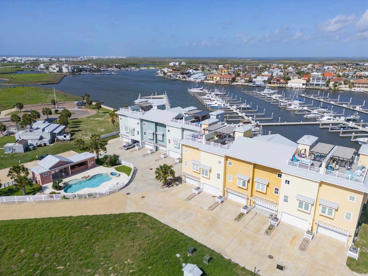 Waterfront vacation rental complex with marina views, swimming pool, and coastal community setting in a picturesque harbor location.