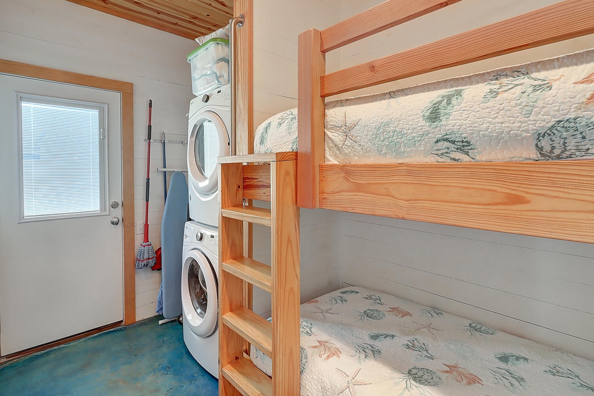 Your private laundry room features stacked washer-dryer and charming bunk beds with coastal-themed linens for extra sleeping space.