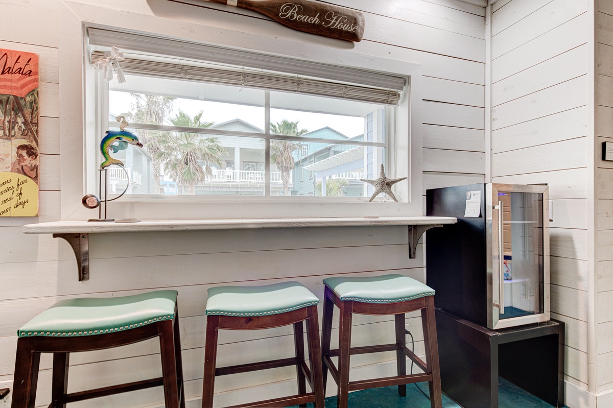 Enjoy your morning coffee at this charming breakfast bar with coastal views and beach house charm.